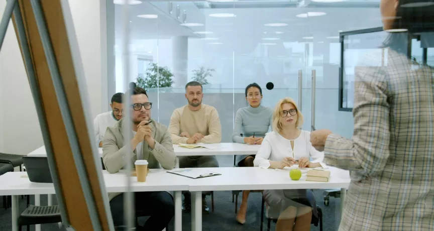 Des salariés avec des profils d'engagement différents écoutent une intervenante qui leur fait face.